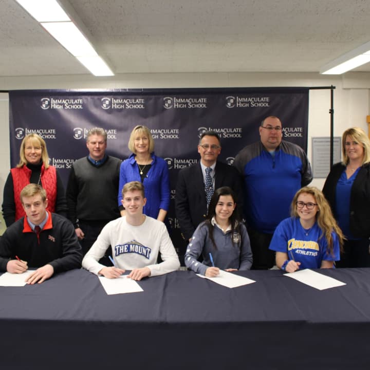 Will Hatcher, Sean Fahey, Danielle Marcone and Kayla Lanza sign National Letters of Intent to play college sports in the fall. All are seniors at Immaculate High School in Danbury.