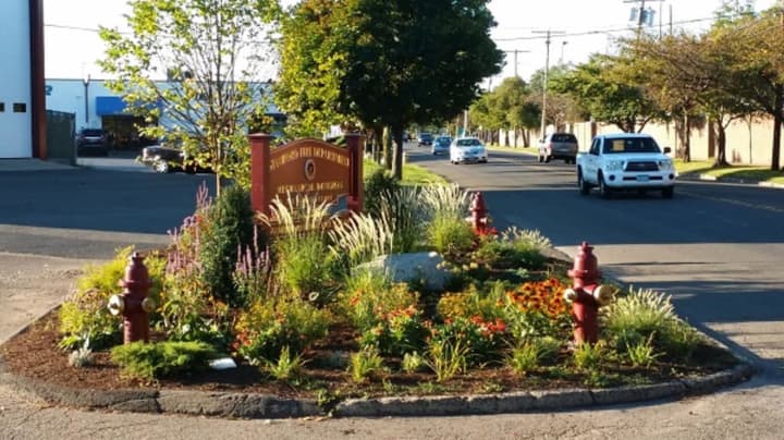A pretty garden is guarded by a phalanx of fire hydrants and graced by a brand-new sign at the Charles McRedmond Firefighters Training Facility on Magee Avenue in Stamford.
