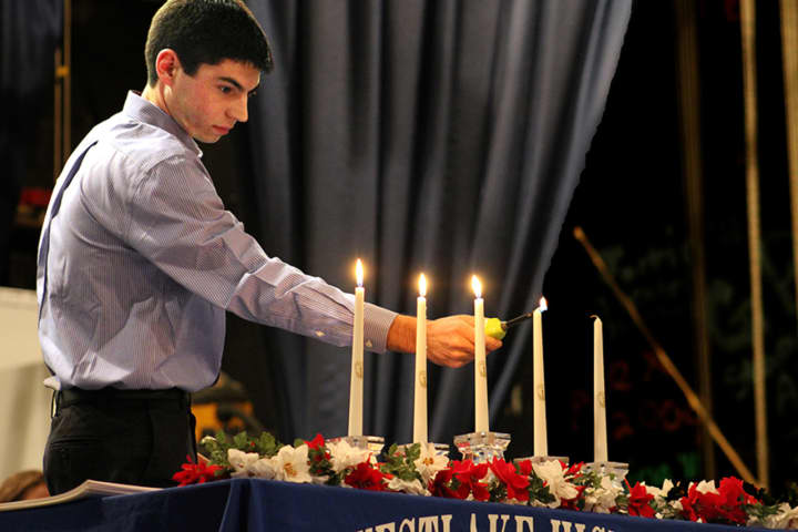WHS senior Steven Brunetto lighting candles during the National Honor Society induction ceremony.