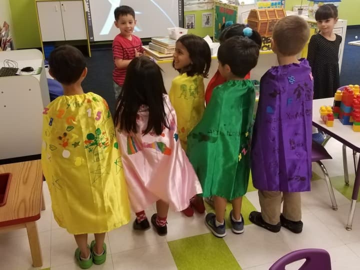 Preschoolers at The Learning Experience show off the capes they made for kids at local hospitals.