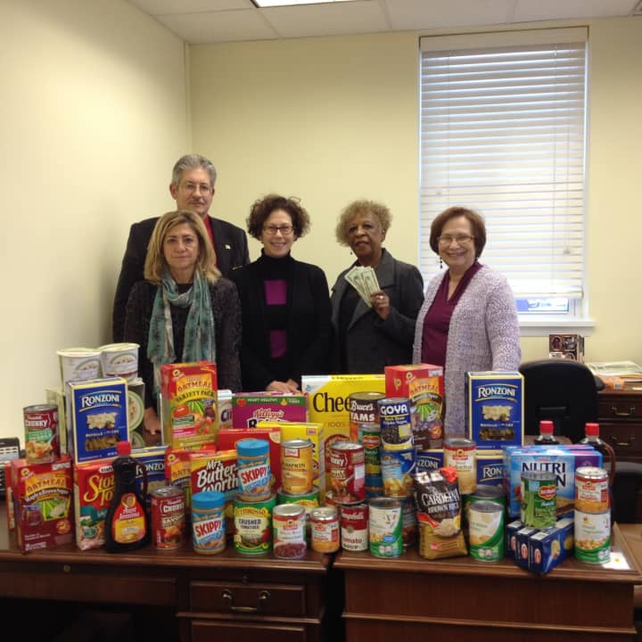 Judith Giordano (far right) and some of the food that was collected along with sales associates Jim Efron, Roula Savva, Susan Levinson and Beverly Mitchell, event chairperson.