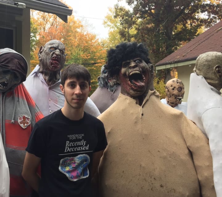 Chris Arturi stands with the zombie wall at his haunted house, Thirty Knapp Road.