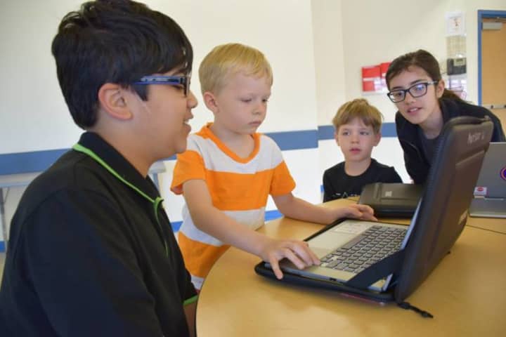 Fifth-graders at Todd Elementary School share their coding knowledge with kindergartners.