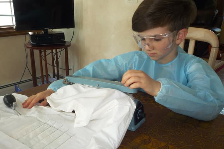 Mark Leschinsky ,9, of Mahwah, works on his prototype for the self-disinfecting suit last year.