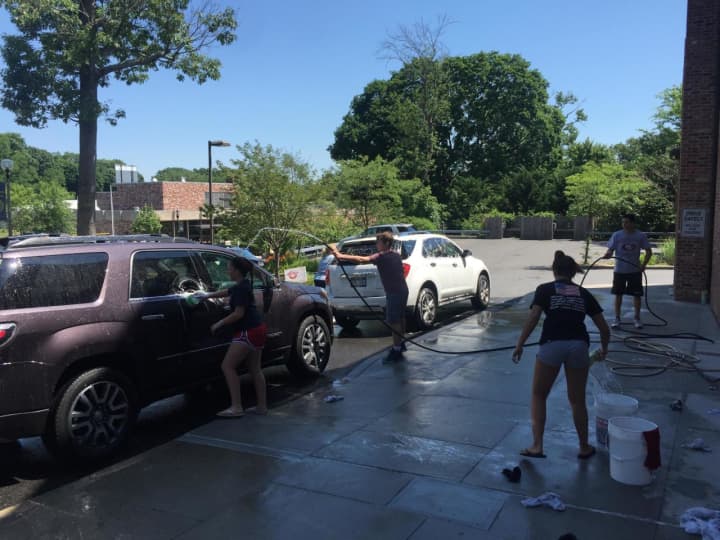 Members of the Village Lutheran Church youth wash a car to help raise funds for an upcoming trip to New Orleans.