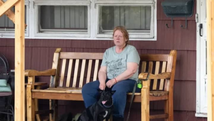 Asa Ellerup, wife of accused Gilgo Beach serial killer Rex Heuermann, sits outside of her Massapequa Park home after being allowed back onto the property Thursday, July 27, following a 12-day police search.