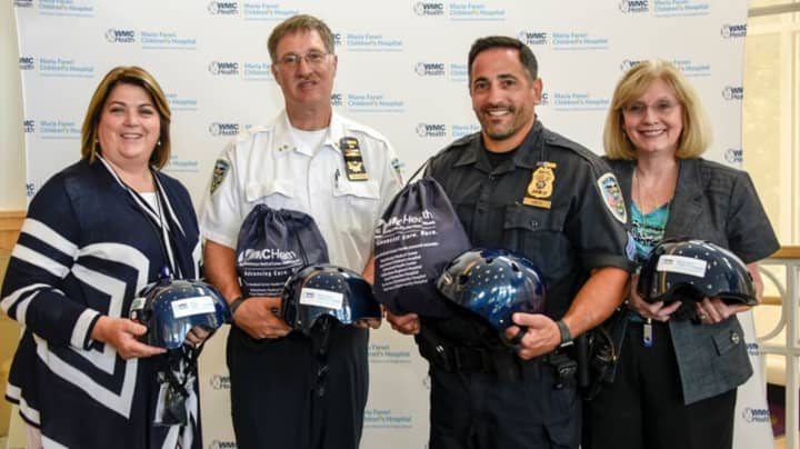 Holding bicycle helmets are (l-r): Mary McCarthy, Westchester Medical Center&#x27;s trauma injury prevention and outreach coordinator; Rye Brook Chief Greg Austin, Sgt. Luigi Greco; and Lynn Kemp, the center&#x27;s regional trauma services administrator.