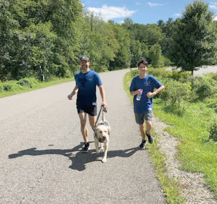 Thomas Panek runs with his son and his guide dog Blaze.