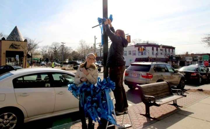 People took to the streets to attach blue ribbons to the downtown for Autism Awareness Month