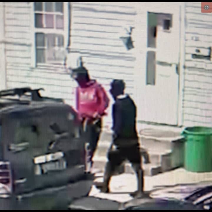 CCTV stills of the suspects wearing a red and a black hoodie.