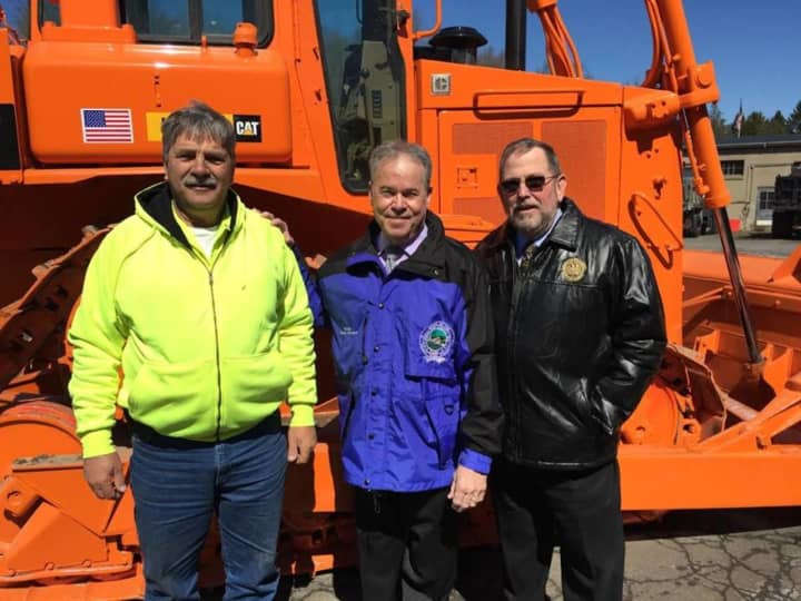 Rockland County Executive Ed Day and County Highway Superintendent Skip Vezzetti stand in front of a refurbished 1988 bulldozer.