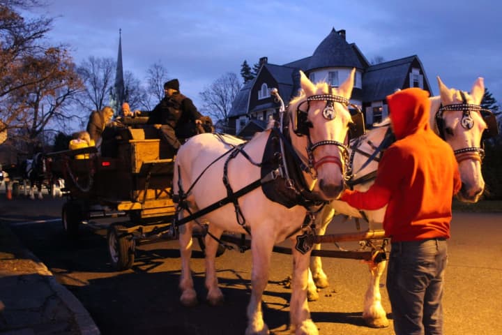 Families can climb onto the horse-drawn carriage rides in front of Pequot Library for a tour of picturesque Southport Village during the 2016 Holiday Caroling Party and Open House.