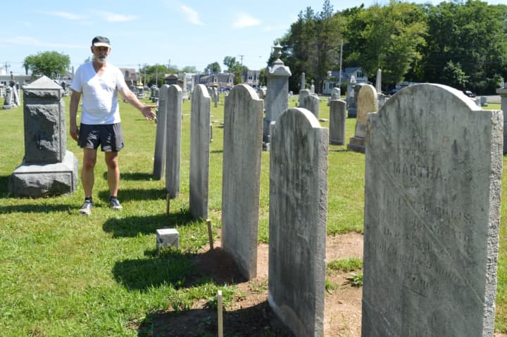 Robert Neal Carpenter stands among a row of repaired headstones that had been knocked to the ground at the Wyckoff Reformed Church Cemetery.