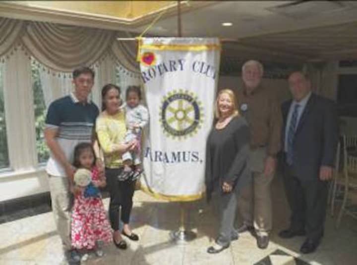 Parents Albert and Joy Dela Pena with Ashlee (standing) and Misha; hosts Helen and Lloyd Astmann; and Paramus Rotary Club President Jay Leone.