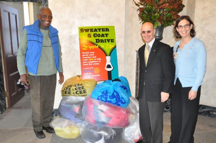 Harry Bright and Bill Fishman receive bags of collected coats and jackets from Alissa Kosowsky on behalf of the employees at NewYork-Presbyterian/Westchester Division.