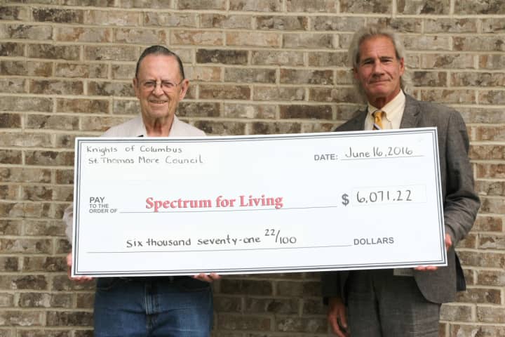 Mike Carpenter, Knights of Columbus St. Thomas More Council #2188 member and Spectrum for Living parent (left) presents a check for $6,071 to Mark Michelson, president and CEO of Spectrum for Living.