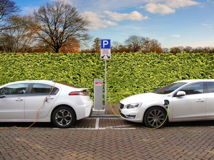 Two electric cars at a charging station.