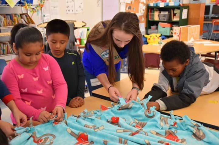 Students at the Carrie E. Tompkins Elementary School in Croton-on-Hudson help Yorktown Girl Scout Alyssa Giannasca make a fleece blanket for patients at Blythedale Children’s Hospital in Valhalla.