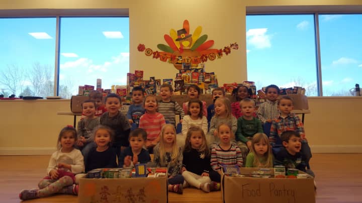 Children at the Goddard School in Yorktown show off some of the food they collected for needy families. 