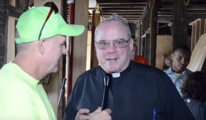 Jim Killoran, left, executive director of Habitat for Humanity of Westchester, speaks with Monsignor Dennis Keane, pastor of Holy Family Church in New Rochelle, at a home Habitat is rebuilding in Yonkers.