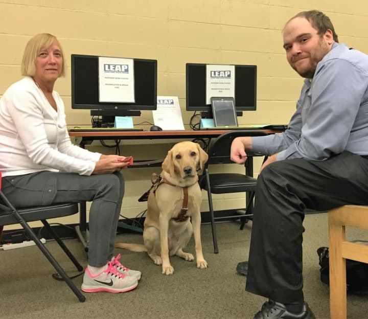 Technology Trainer Kevin Rutan with Paula Webber, technology center user, and her guide dog, Abby.