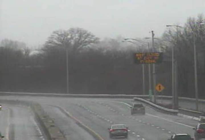 A sign on I-95 in Stratford warns of a closed exit ramp as heavy rain falls across the area.