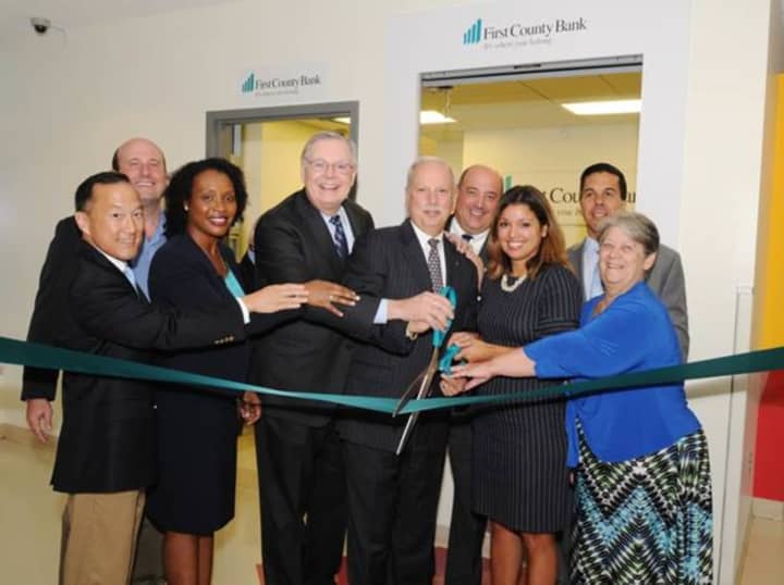 Representatives of First County Bank and Stamford Public Schools perform the ribbon-cutting ceremony, officially opening the bank&#x27;s new limited access branch at the Academy of Information Technology and Engineering in Stamford.