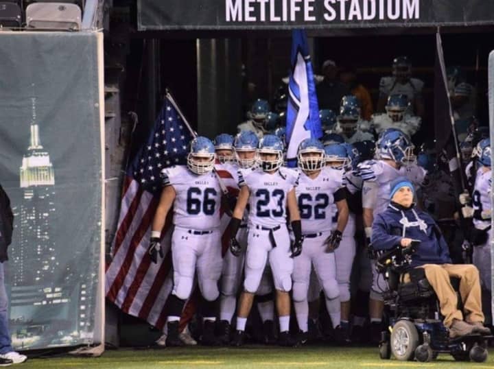 Wayne Valley High School Co-Captain Jake Pluta carries the historic American flag onto the field.