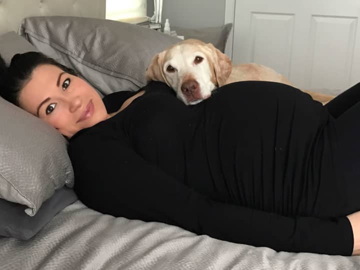 Max lays on a pregnant Jessica Galarza.
