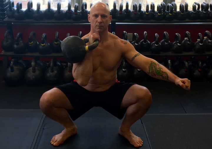 American Eagle MMA owner Phil Ross of Mahwah does a kettle bell squat.