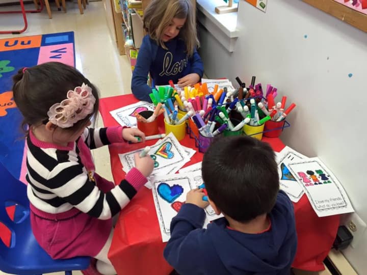 Kids color during Valentine crafting at Grace Nursery School.