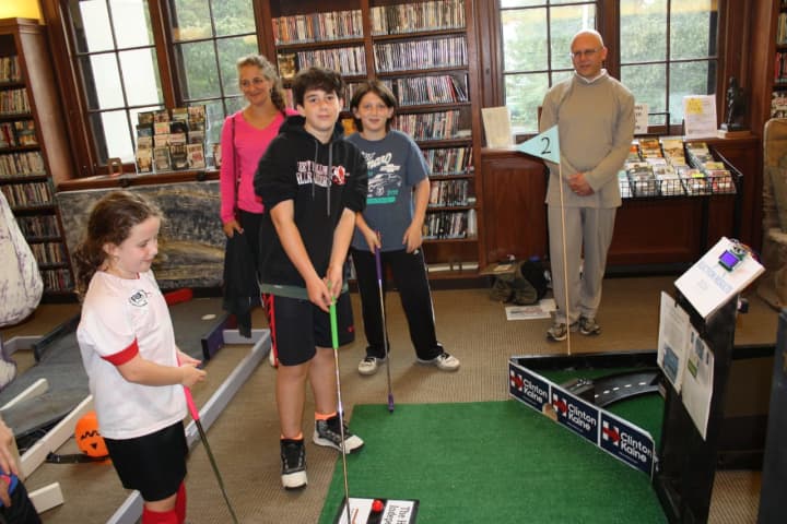 Kids play a round of haunted mini-golf at the Warner Library.
