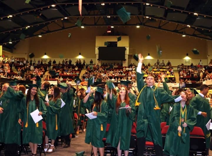 Newly minted Lakeland High School graduates toss their caps high in the air after being pronounced &quot;alumni&quot; Saturday.