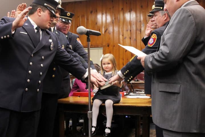 Leonia Fire Chief Dan Neu&#x27;s daughter holds Bible during Monday night&#x27;s swearing in.