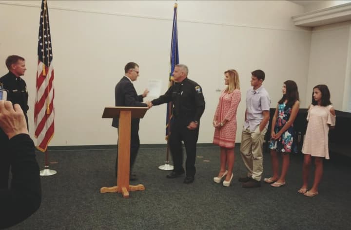 Massimo D&#x27;Elia is sworn in by Commissioner Rich Colangelo in front of his wife and kids while Chief Tim Shaw looks on