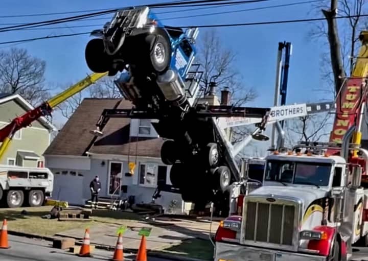 Roosevelt Street in Cresskill: Crane from O&#x27;Brother Tree Service of Bergenfield tips.