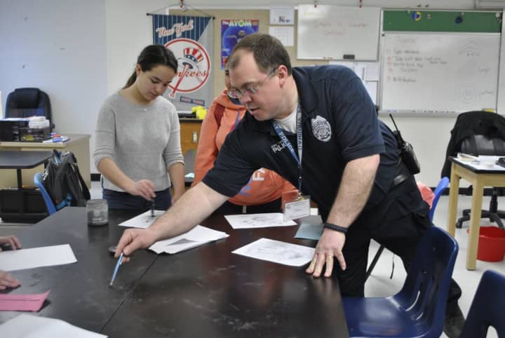 Students learn how to dust for fingerprints and even take their own fingerprints under the direction of Danbury police officer David Antedomenico during a March 22 career fair at Rogers Park Middle School.