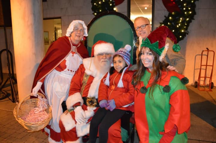 Danbury Mayor Mark Boughton, top right, visits Santa, Mrs. Claus and an elf with a young fan at the tree lighting event at the library. 
