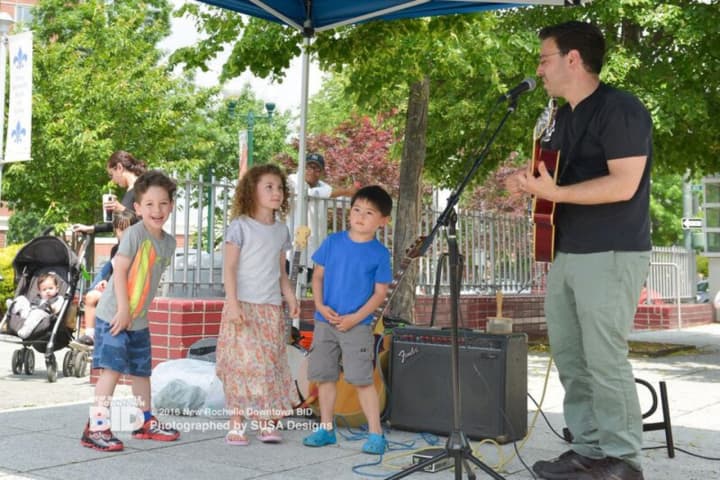 Children enjoy listening to music on the opening day of the New Rochelle Grand Market.