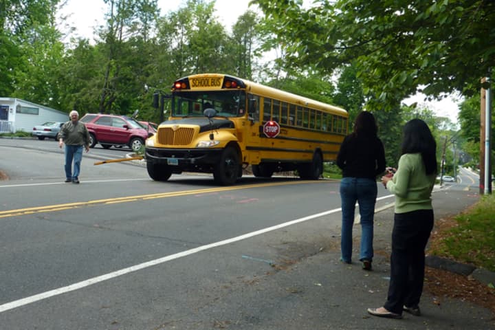 Westport resident Betty Tsang (back right) uses the &quot;Where&#x27;s Our School Bus?&quot; app on her iPhone Monday afternoon to confirm the arrival of her daughter&#x27;s bus, alerting parents nearby that the bus is on its way.