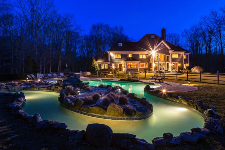 The property at 1 Stillwater Place in Bedford, marketed by Douglas Elliman, features a 80-foot lazy river pool.