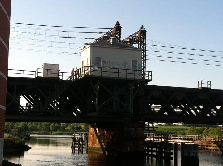 Flag men are spotted on the stuck train drawbridge Friday evening over the Norwalk River.