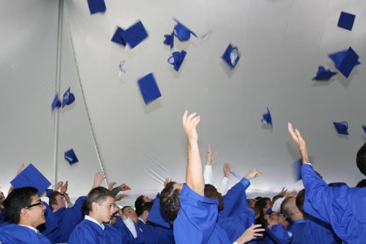 Eastchester High School graduates toss their caps in the tent last week.