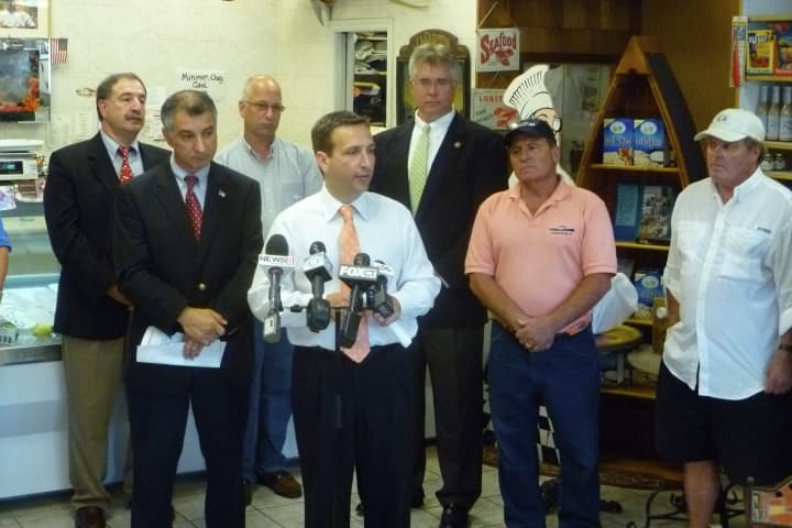 State Sen. Bob Duff (D-Norwalk, Darien), center, addresses members of the media in Darien Seafood Market, as other elected officials and several lobstermen look on.