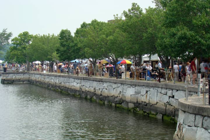 Exhibit booths line the Saugatuck River at Parker-Harding Plaza in downtown Westport during a past year&#x27;s Westport Fine Arts Festival.