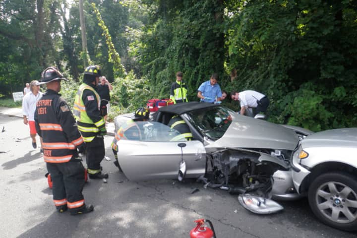 Westport firefighters and EMS work to get an injured driver out of a damaged Corvette Friday afternoon following a five-car pileup on Riverside Avenue.