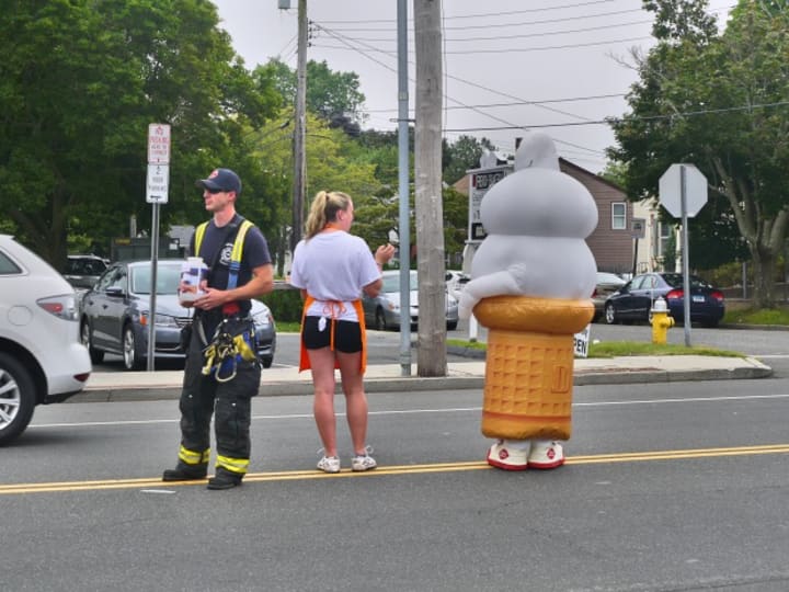 Employees of the Fairfield Dairy Queen are joined in the street by members of the Fairfield Fire Department to help raise money on Thursday. 