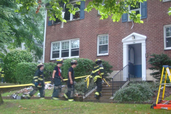 Harrison firefighters head into the house on Underhill Avenue where a woman was killed in a fire early Tuesday.