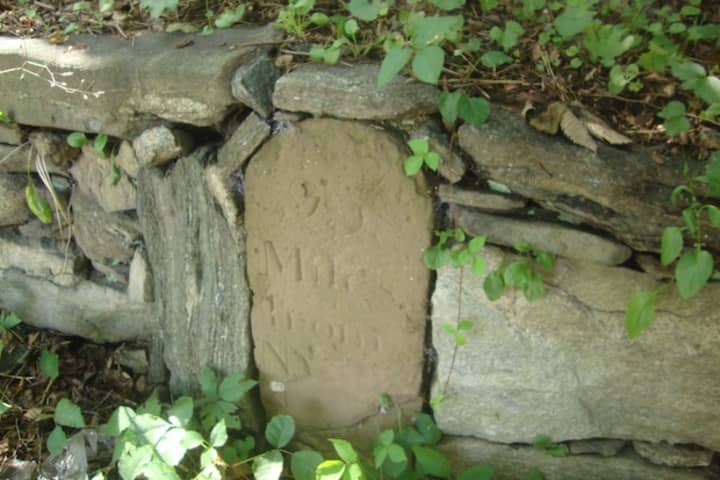 Rye historic Mile Marker 25, placed along the Boston Post Road in 1763. The marker&#x27;s writing has faded and a plaque denoting its historical significance has been removed.