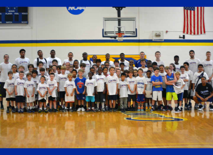 Members of the Concordia College men&#x27;s basketball team pose with campers for the team&#x27;s annual youth basketball clinic.